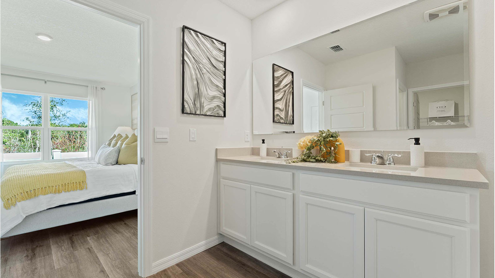 Primary bathroom attached to primary bedroom with dual vanity sink and walk in closet