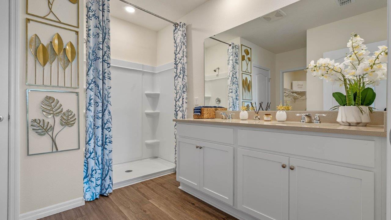 Primary bathroom with double vanity sinks and walk in shower