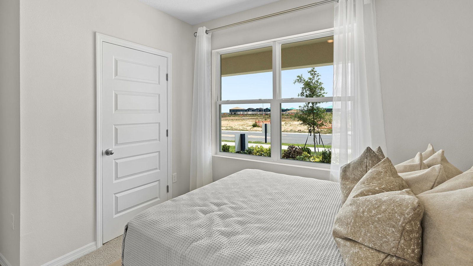 Guest bedroom with large windows and carpet
