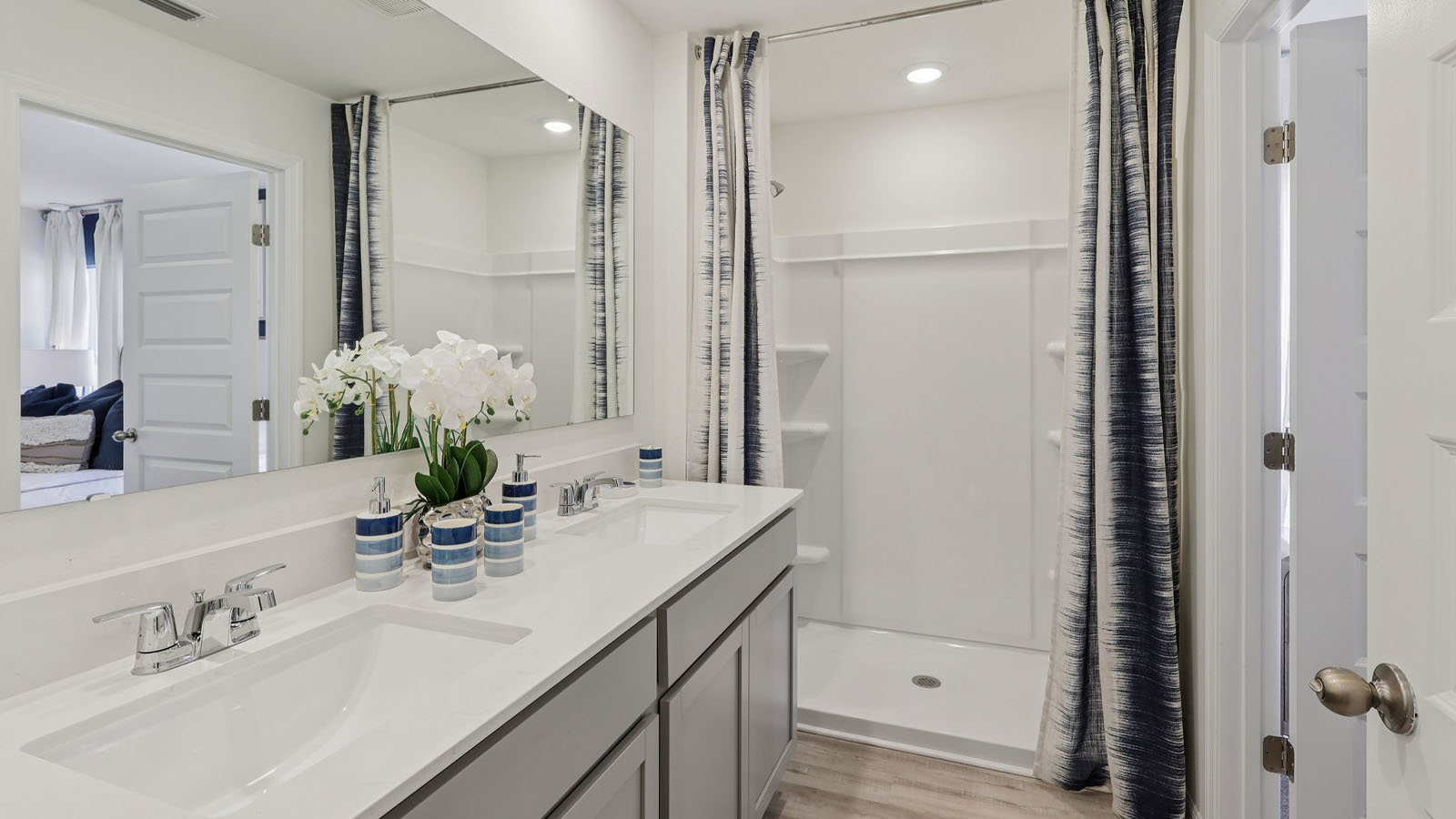 Primary bathroom with dual vanity sinks and walk-in shower