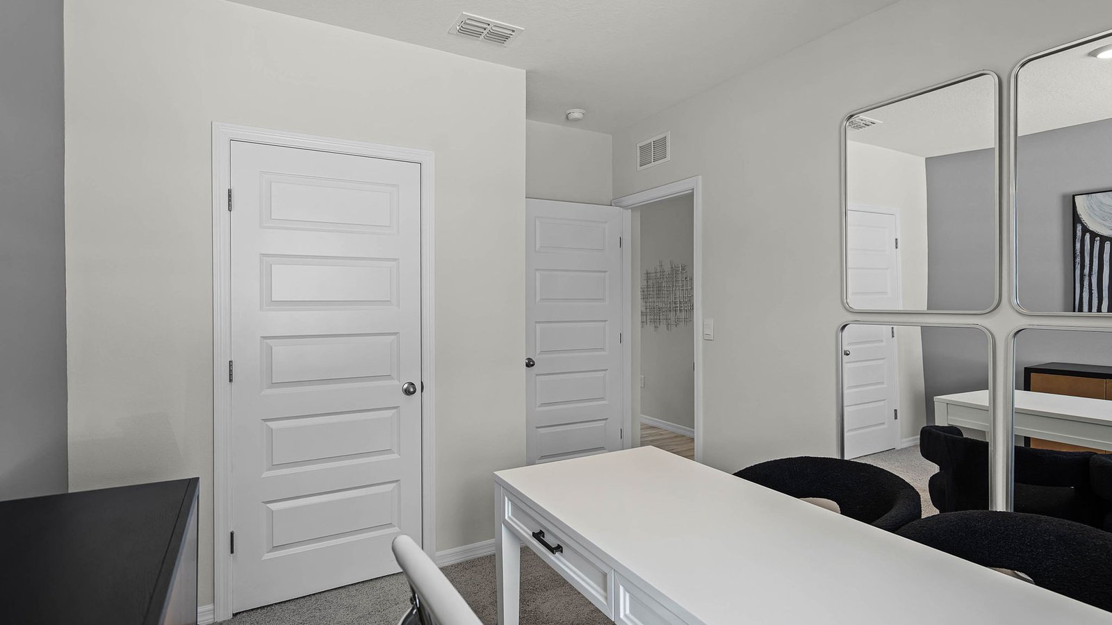 guest bedroom converted into an office with carpet throughout and a closet