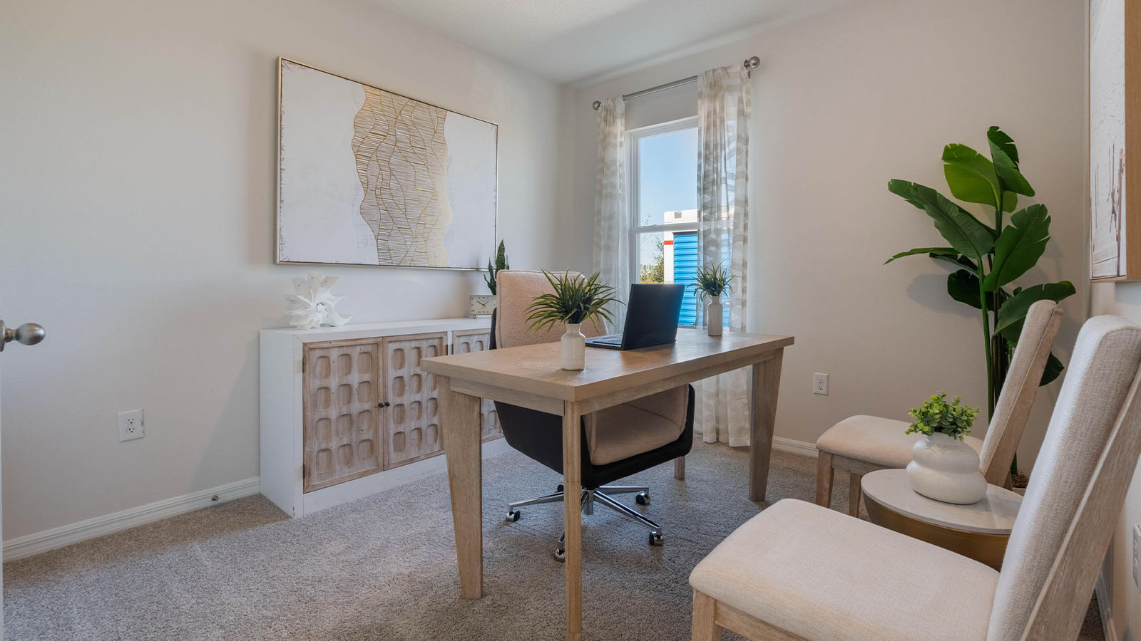 Office with desk and chairs and carpet throughout the room
