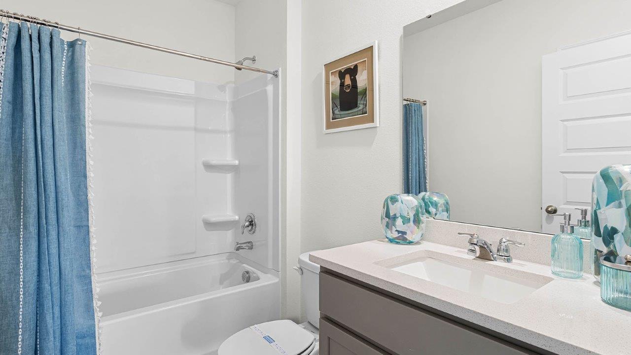 Guest bathroom with quartz countertops and tub