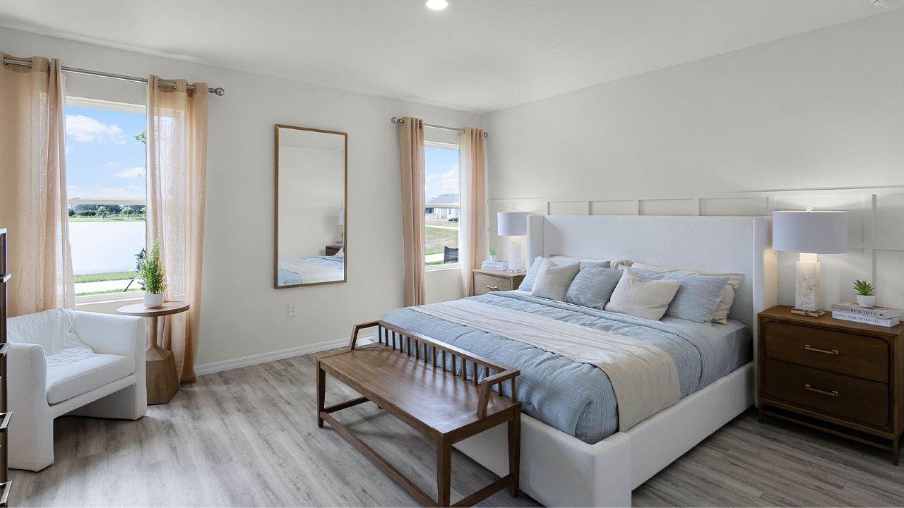 Spacious primary bedroom with two windows for natural light and sitting area