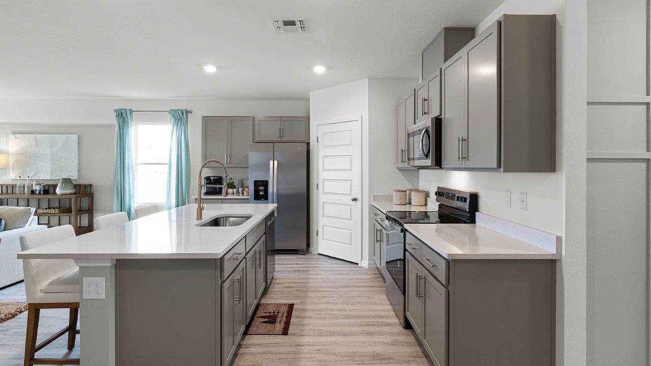Spacious kitchen with large island, quartz counter tops and sleek gray cabinets