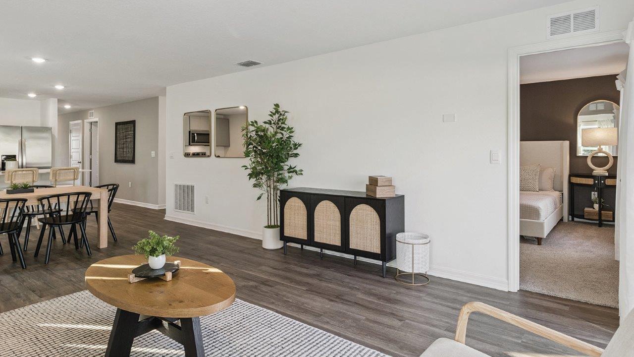 Living room with Luxury Vinyl Plank Flooring throughout adjacent to the primary bedroom