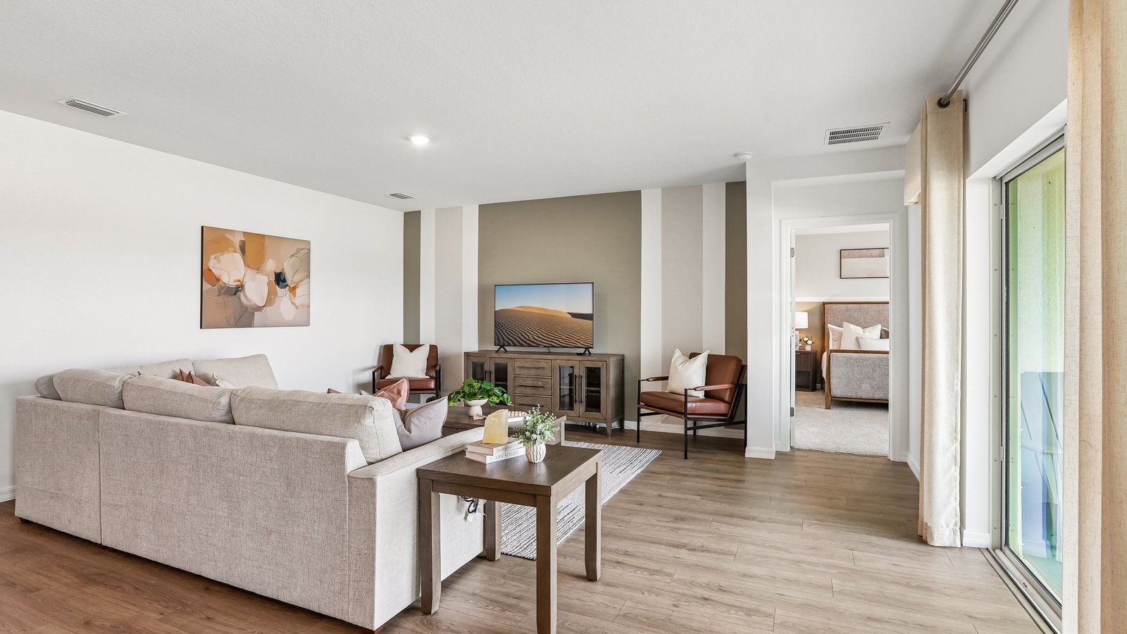 Open concept living area with couch seating and access to the backyard thru slider door.