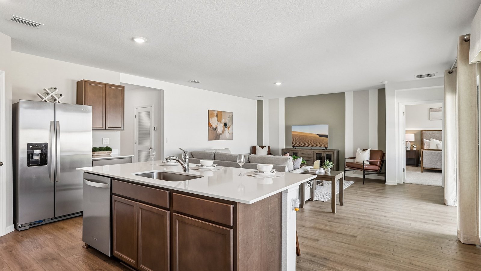 Kitchen with island seating, quartz counters, spacious pantry and stainless-steel appliances.