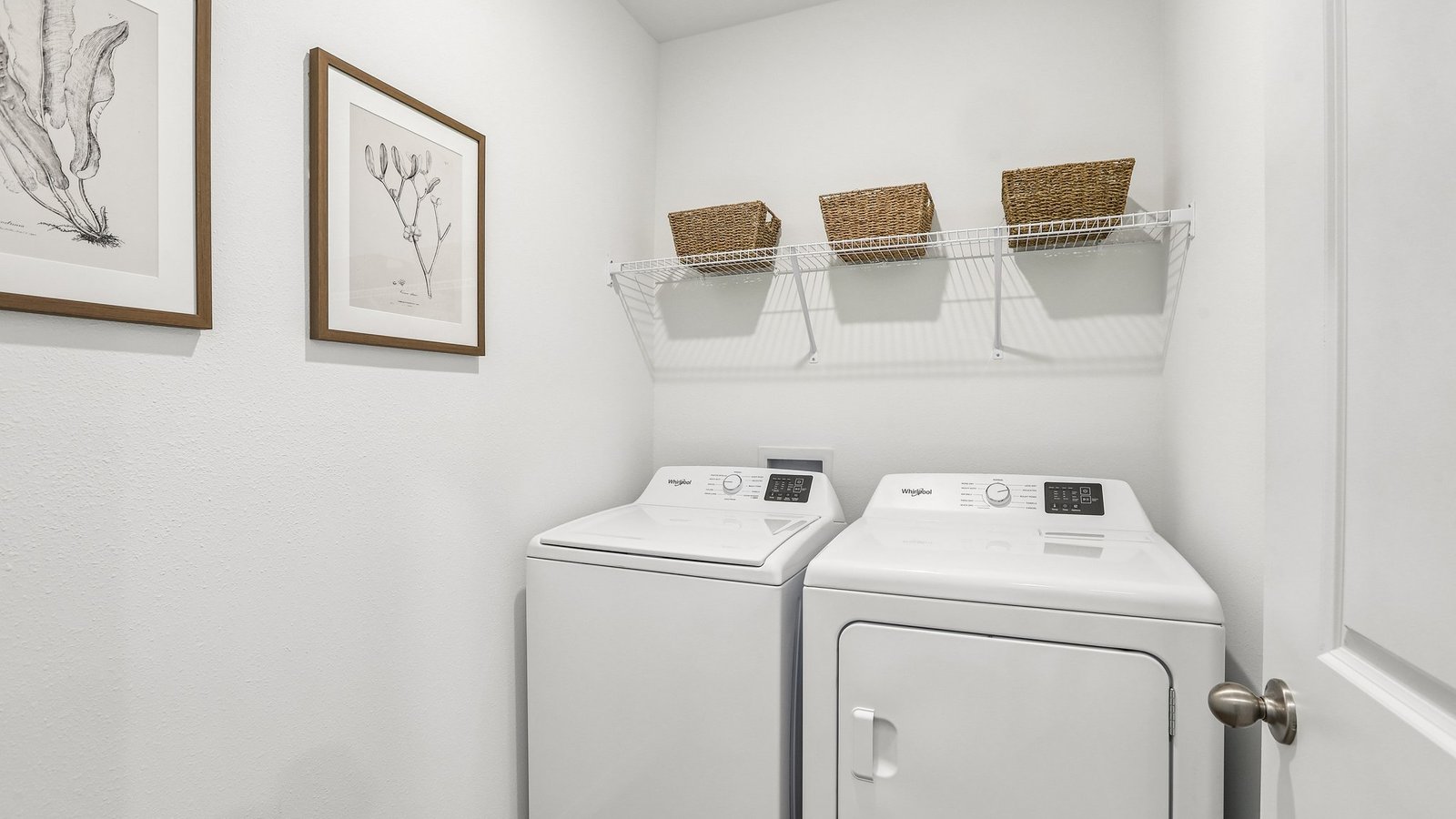 Laundry room with washer and dryer hookups and wall shelving.