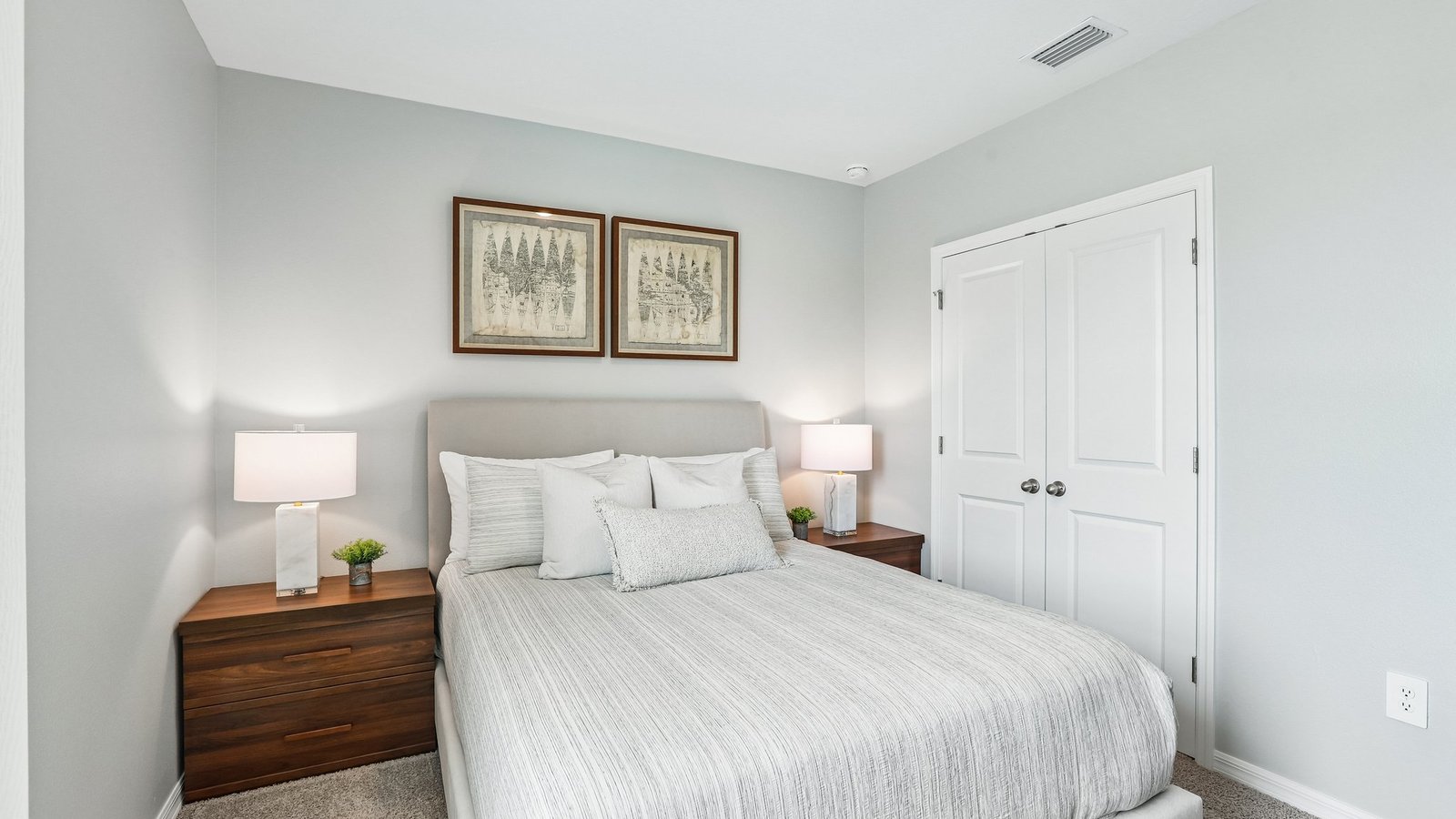 Guest bedroom with bed, nightstands and a roomy closet for storage.