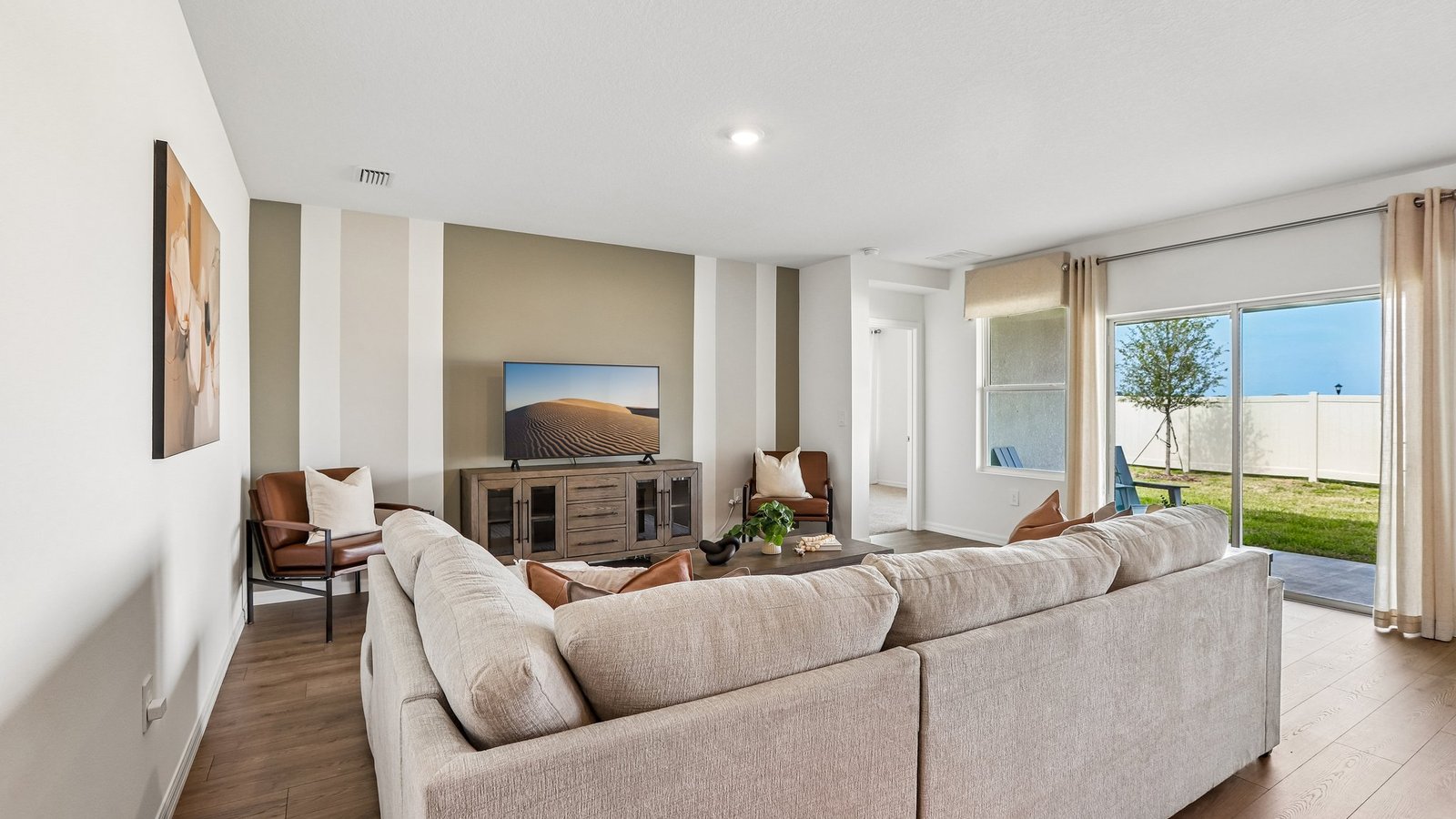 Open concept living area with couch seating and access to the backyard thru slider door.