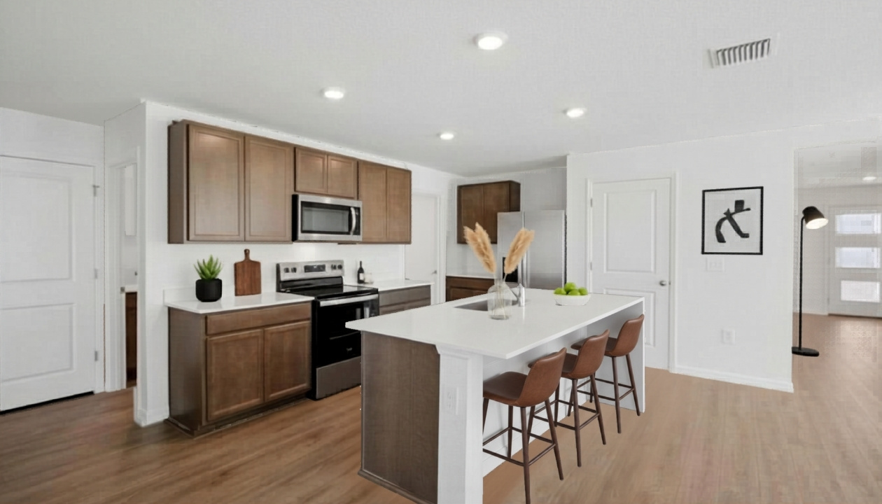 Kitchen with island seating, quartz counters, spacious pantry and stainless-steel appliances.