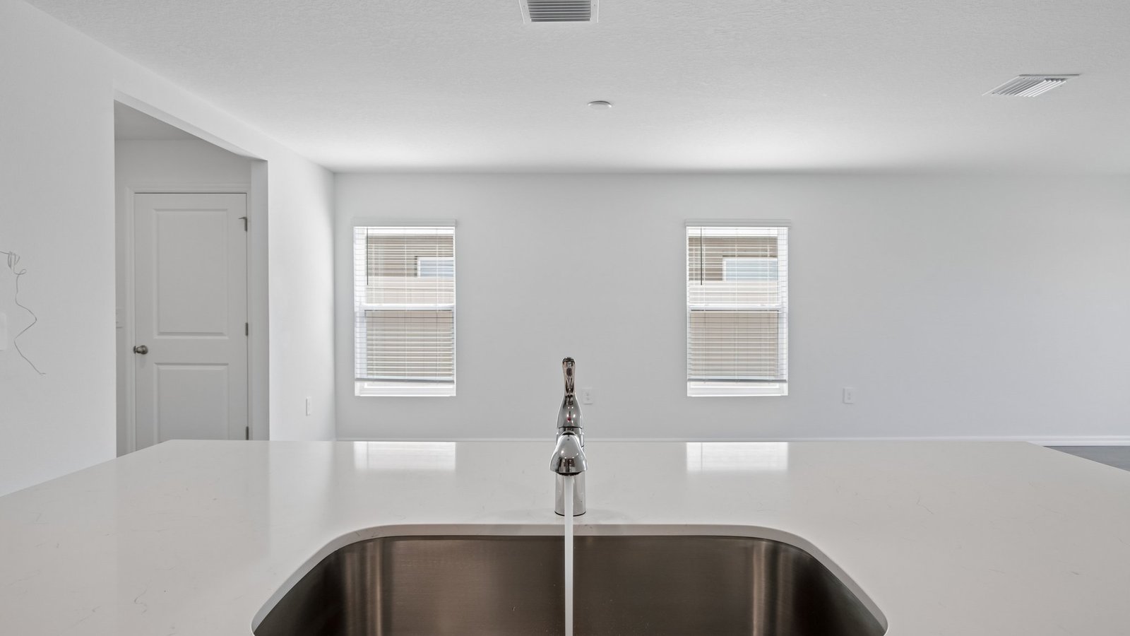 Kitchen with island seating, quartz counters, spacious pantry and stainless-steel appliances.