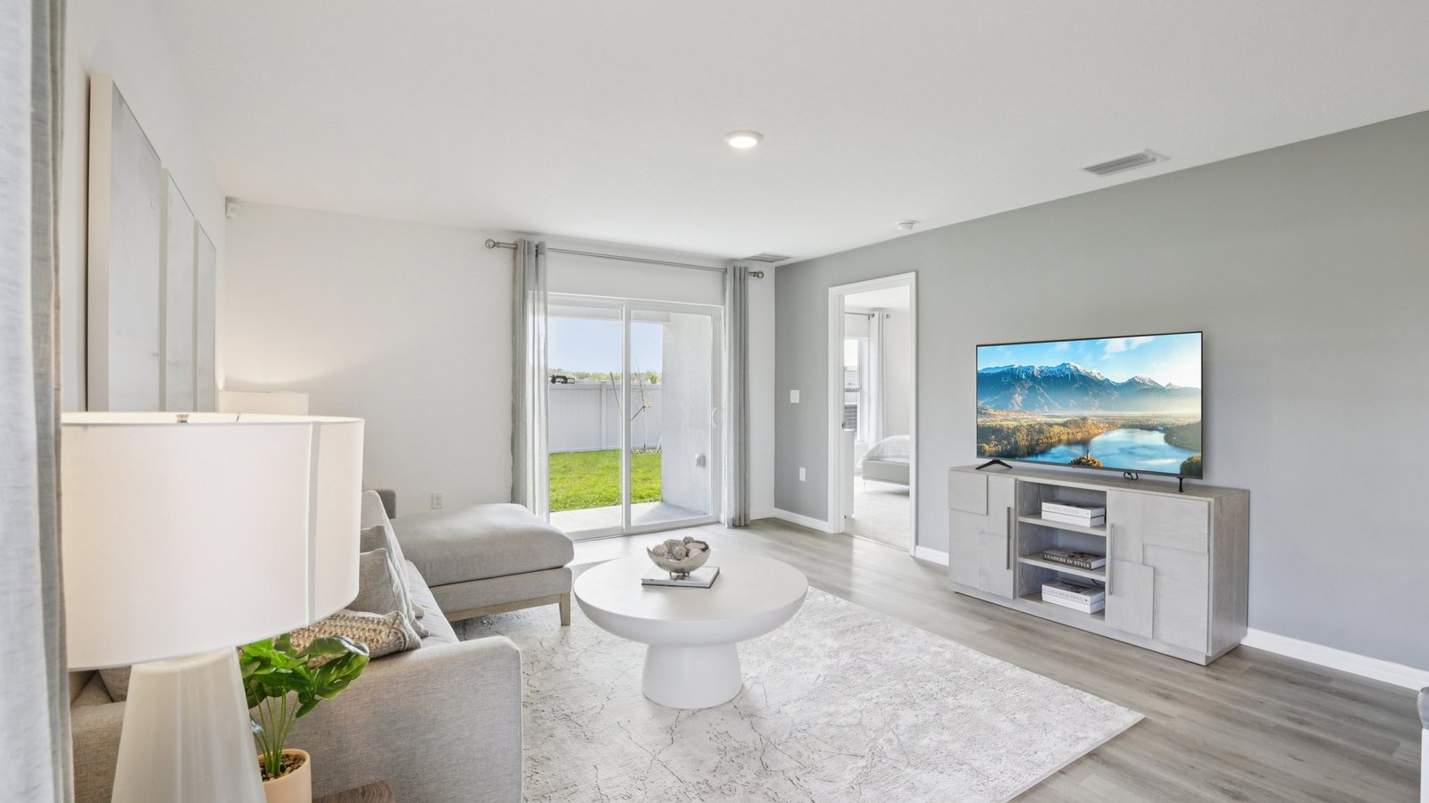 Open concept living area with couch seating and access to the backyard thru slider door.