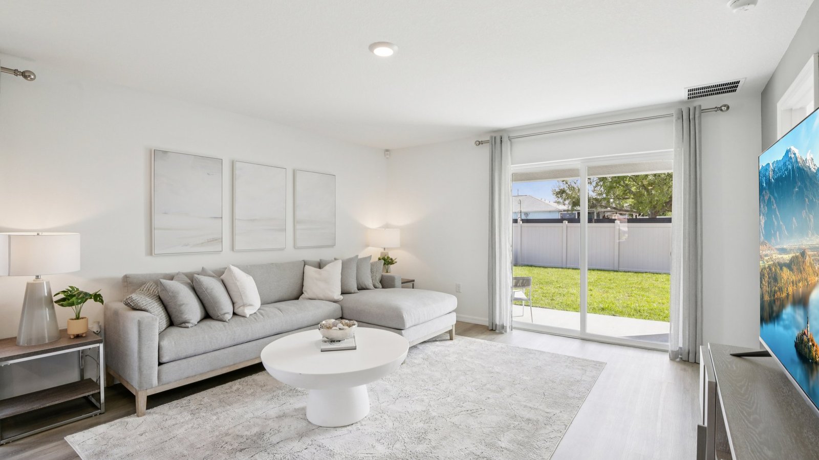 Open concept living area with couch seating and access to the backyard thru slider door.