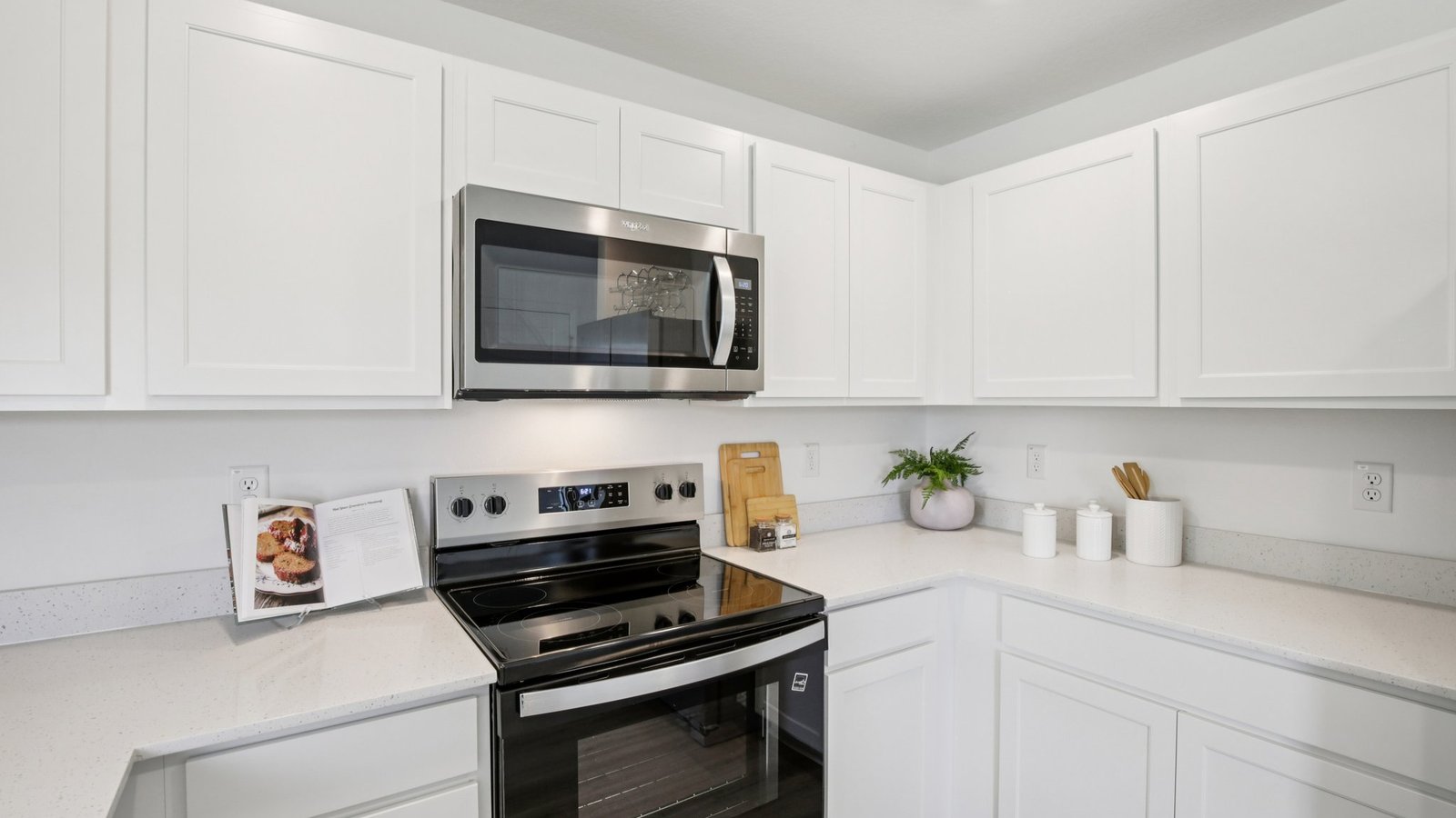 Kitchen with island seating, quartz counters, spacious pantry and stainless-steel appliances.