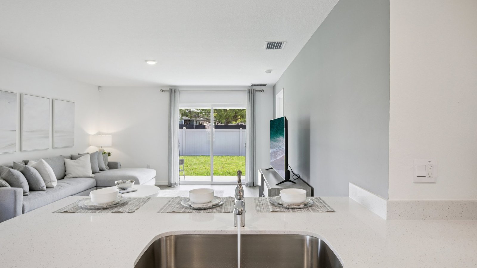 Kitchen with island seating, quartz counters, spacious pantry and stainless-steel appliances.
