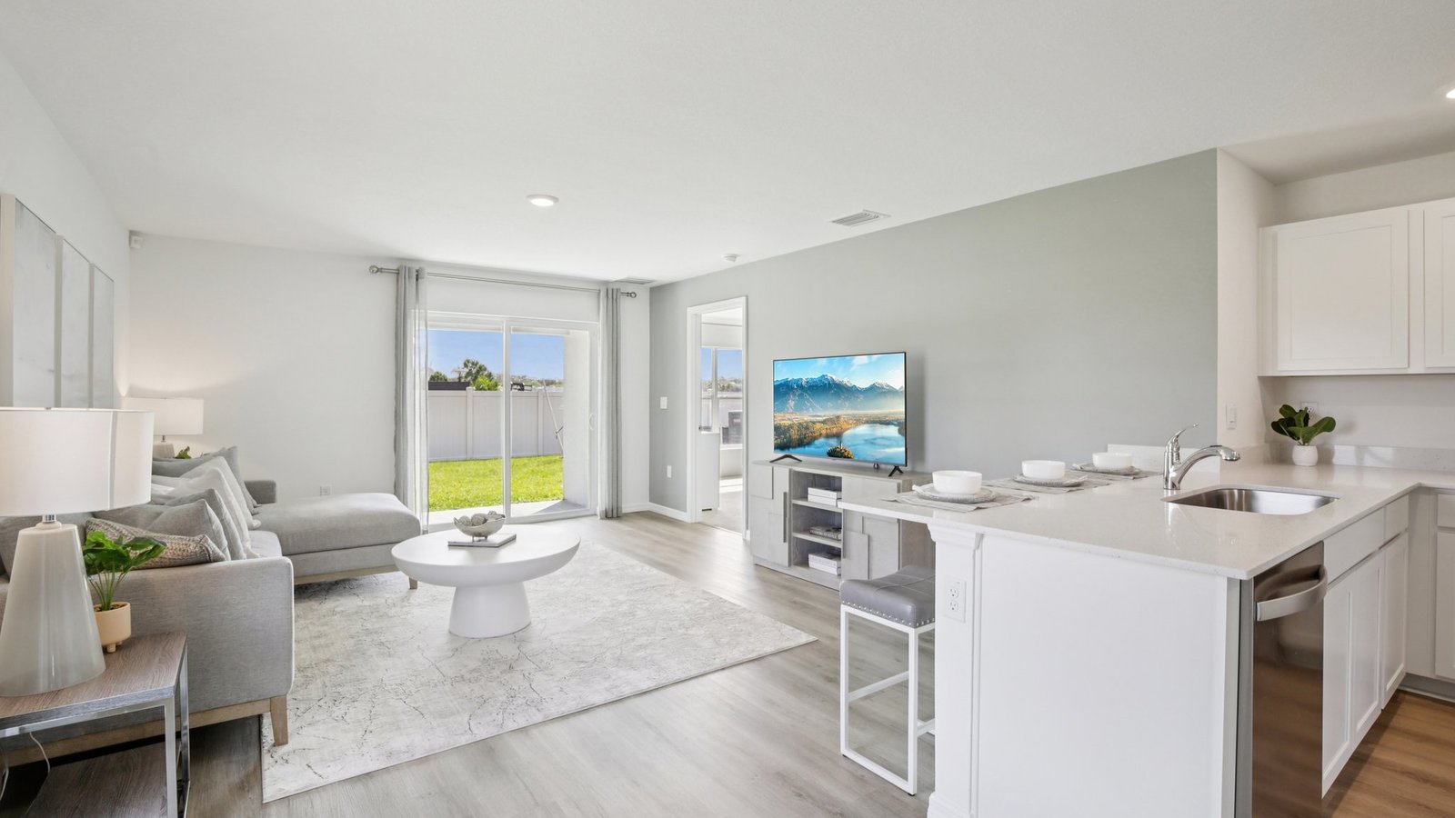 Open concept living area with couch seating and access to the backyard thru slider door.