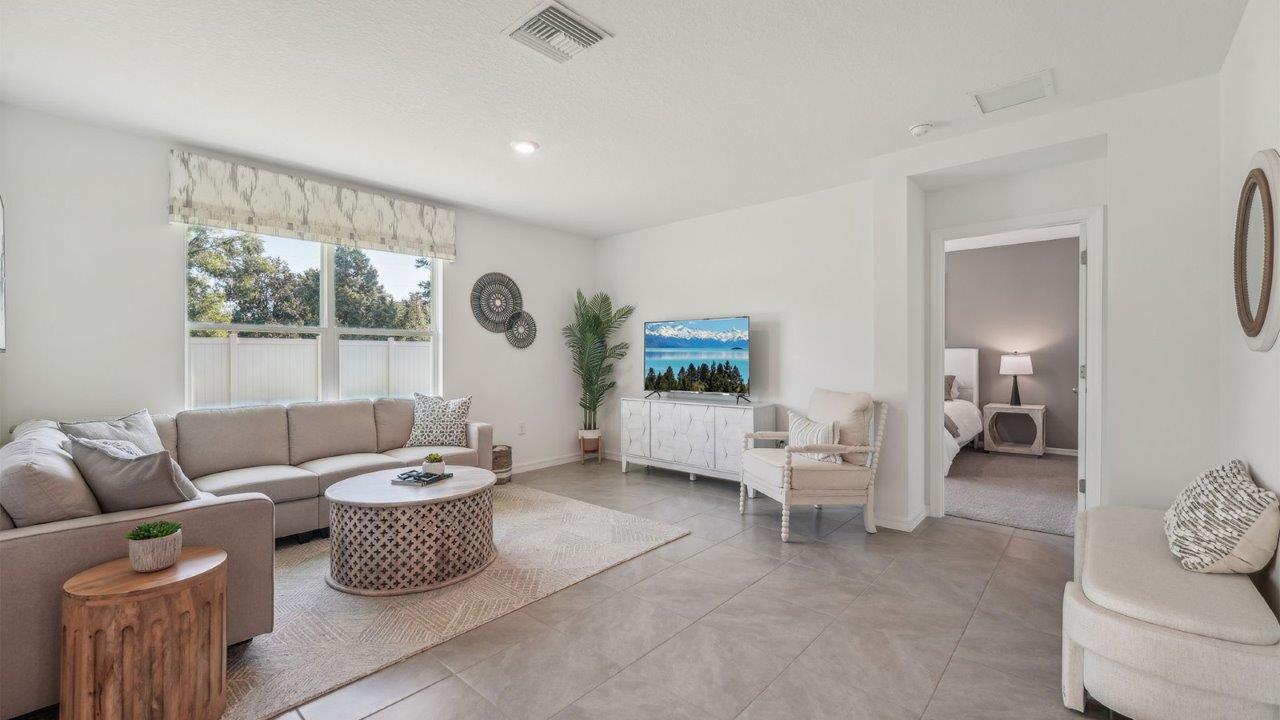 Open concept living area with couch seating and access to the backyard thru slider door.