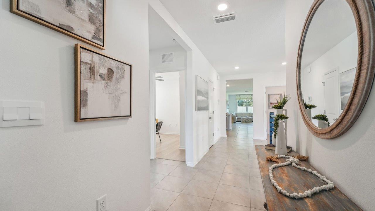 Home entry way thru the front door with tile flooring and a view to the living space.