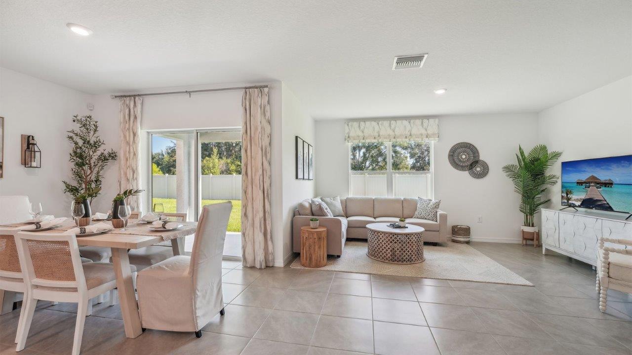 Dining room adjacent to the kitchen with table, chairs and tile flooring.