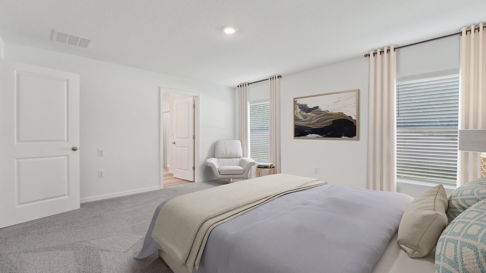 Spacious primary bedroom with king size bed, carpet flooring, natural lighting and a walk in closet.