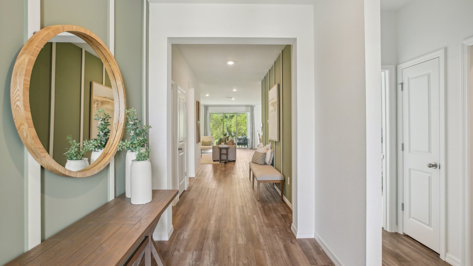 Home entry way thru the front door with LVP flooring and a view to the living space.