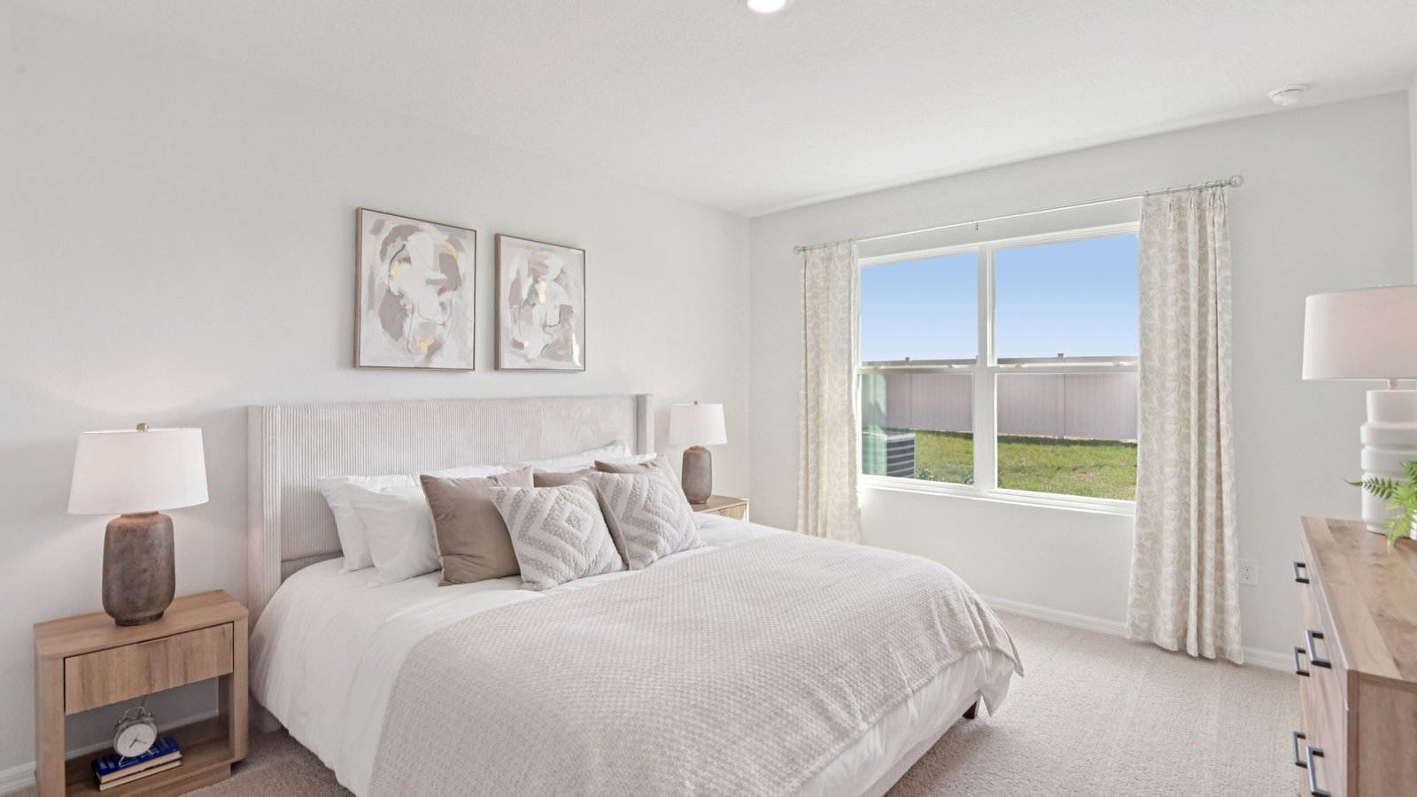 Spacious primary bedroom with king size bed, carpet flooring, natural lighting and a walk in closet.