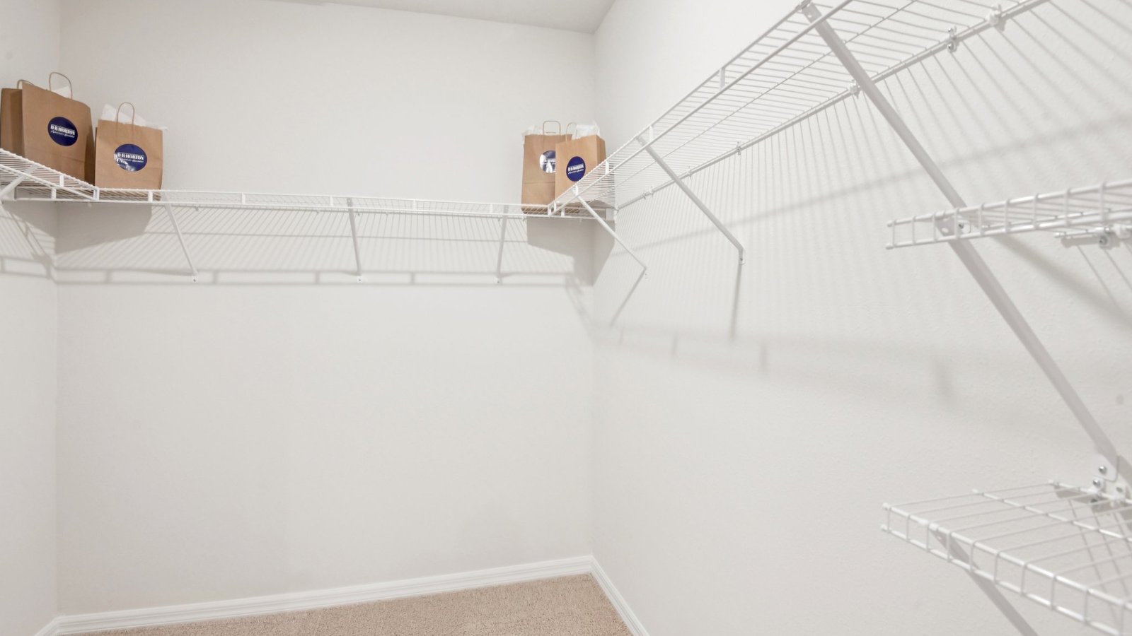 Spacious walk in closet with abundant shelving and storage.