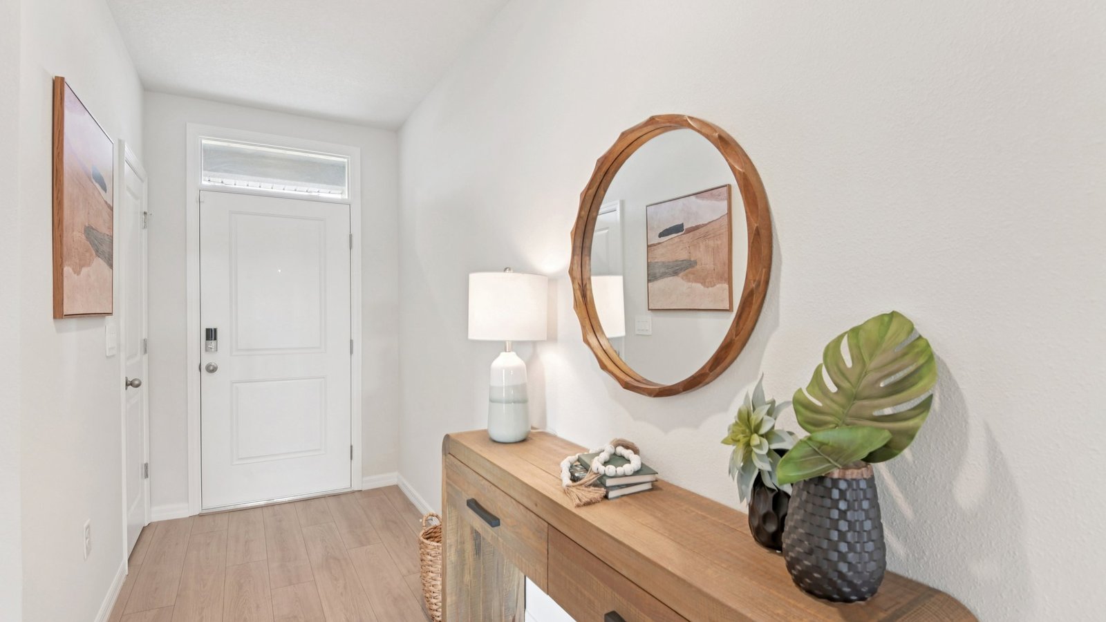 Home entry way thru the front door with LVP flooring and a view to the living space.