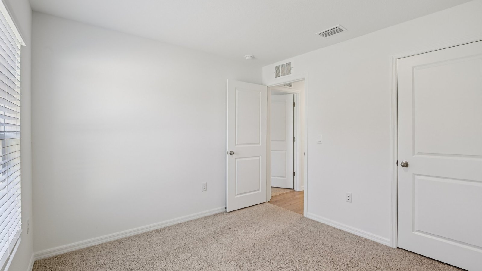 Spare bedroom for guests, with bed, dresser, and ample closet storage.