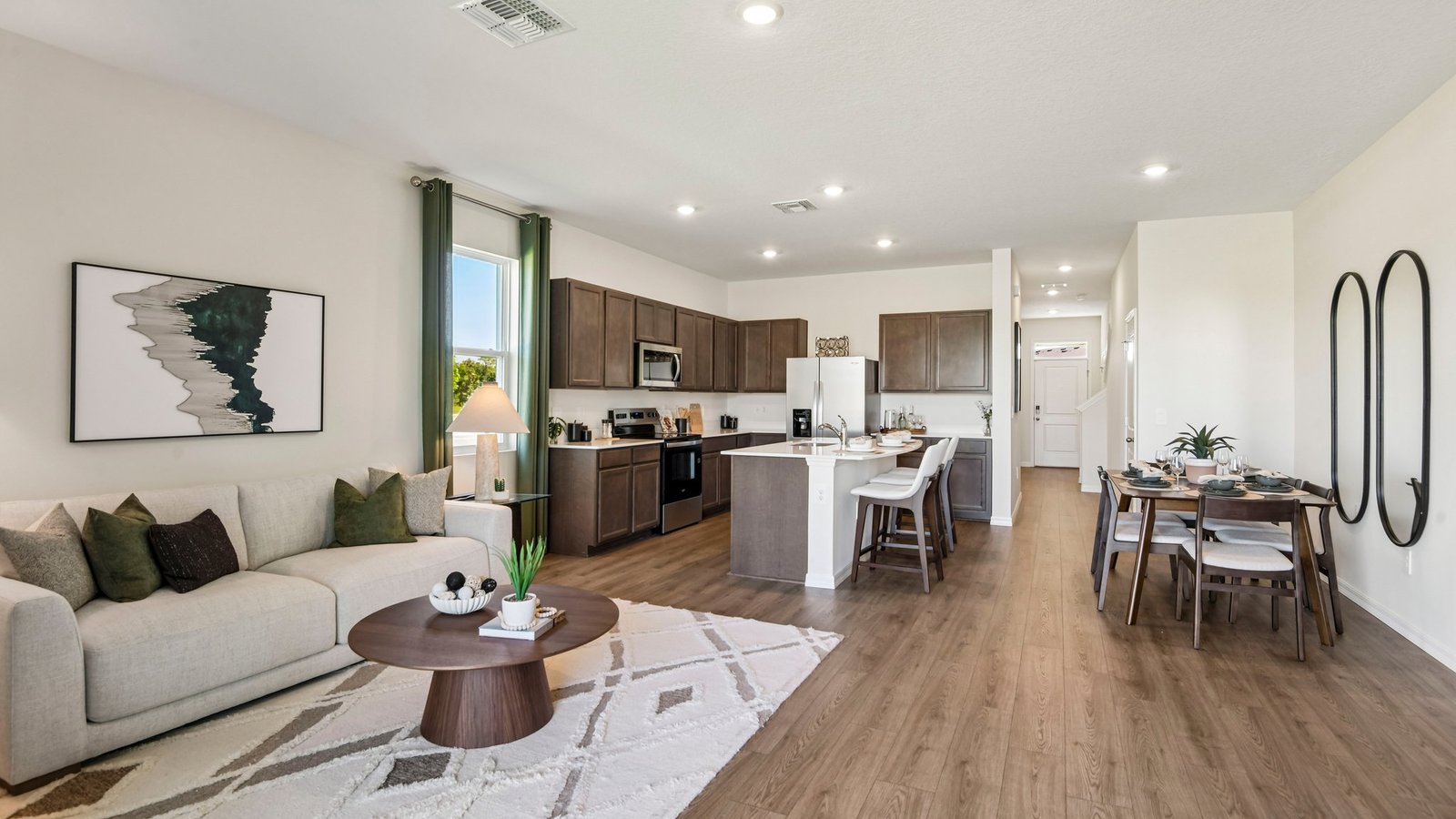 Kitchen with island seating, quartz counters, spacious pantry and stainless-steel appliances.