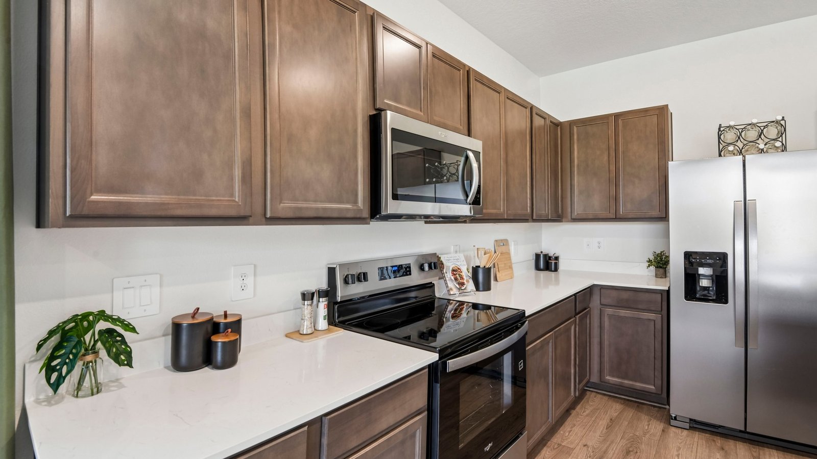 Kitchen with island seating, quartz counters, spacious pantry and stainless-steel appliances.