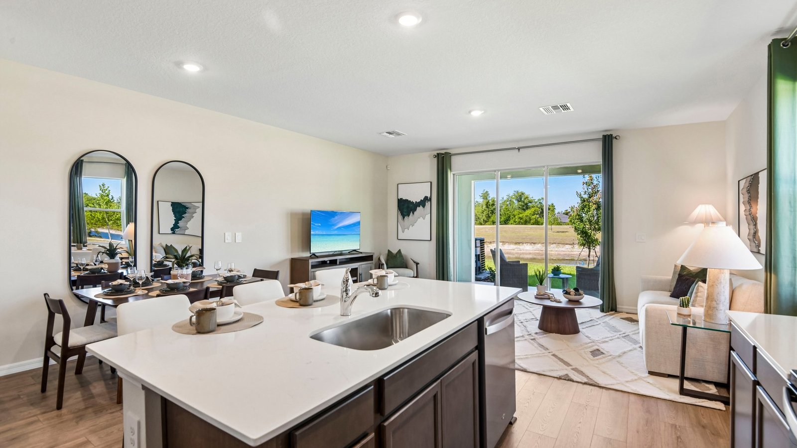 Kitchen with island seating, quartz counters, spacious pantry and stainless-steel appliances.