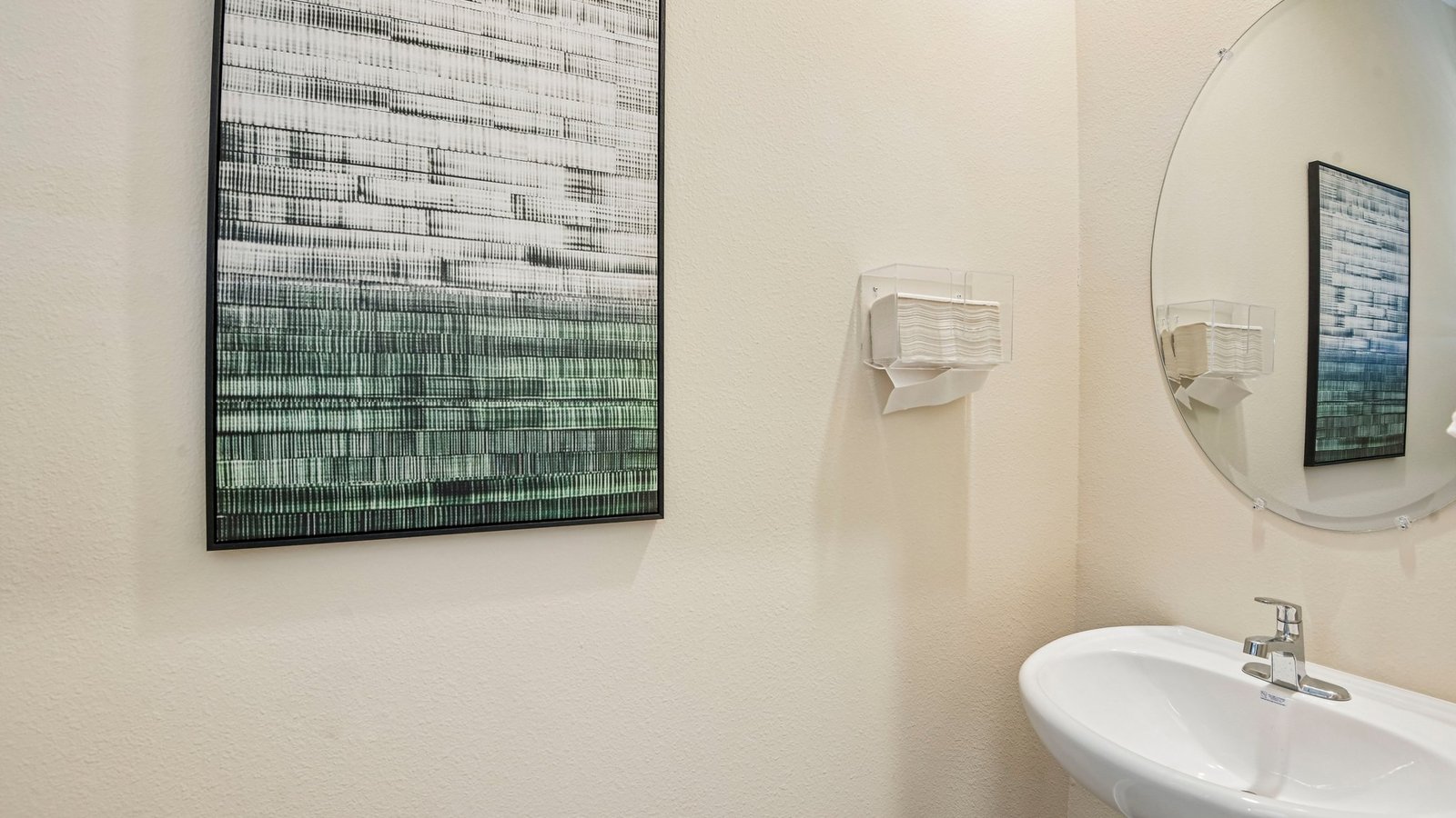 Modern bathroom with single bowl sink, quartz vanity, wall mirror, cabinets and toilet.