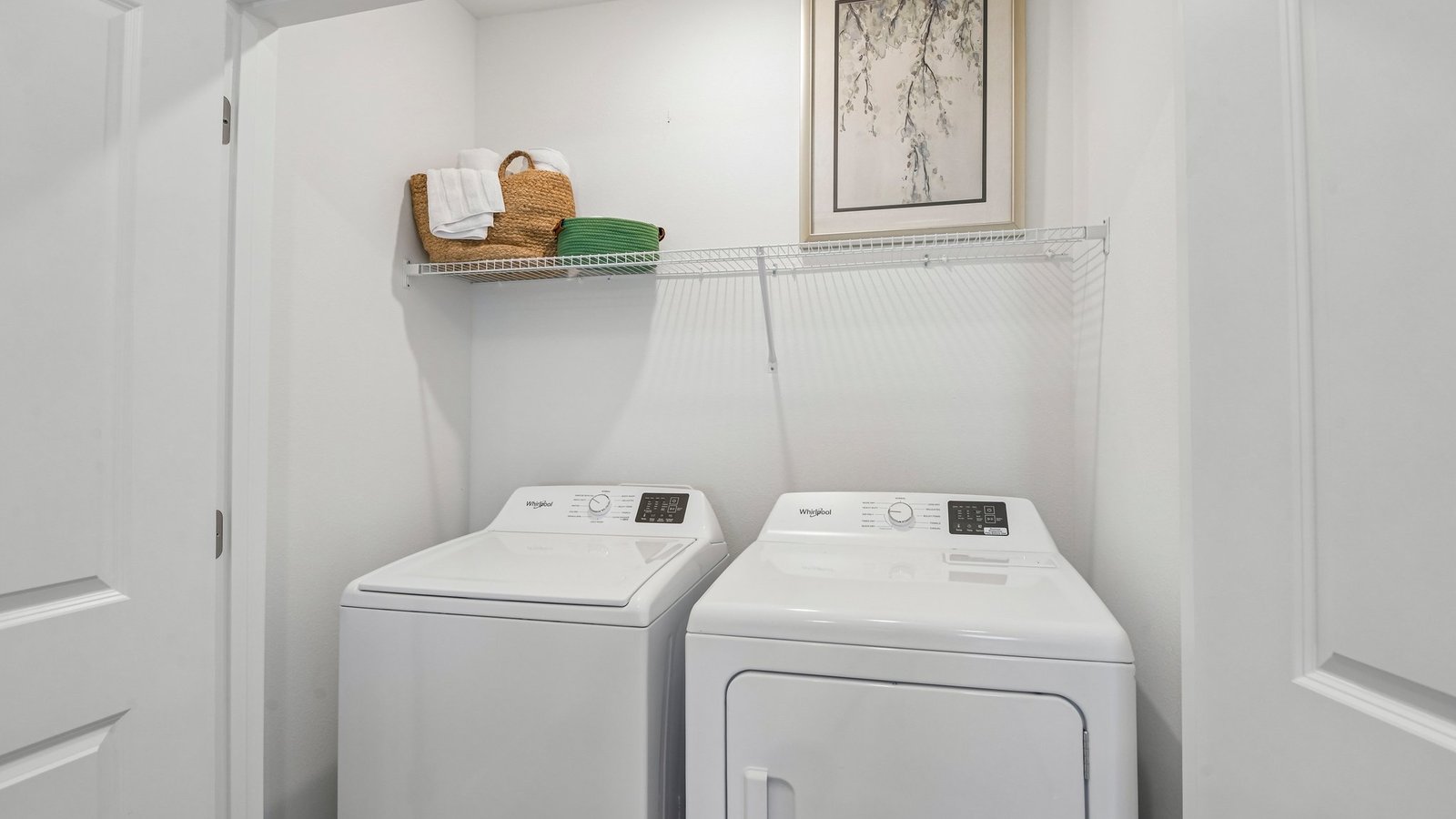 Laundry room with washer and dryer hookups and wall shelving.