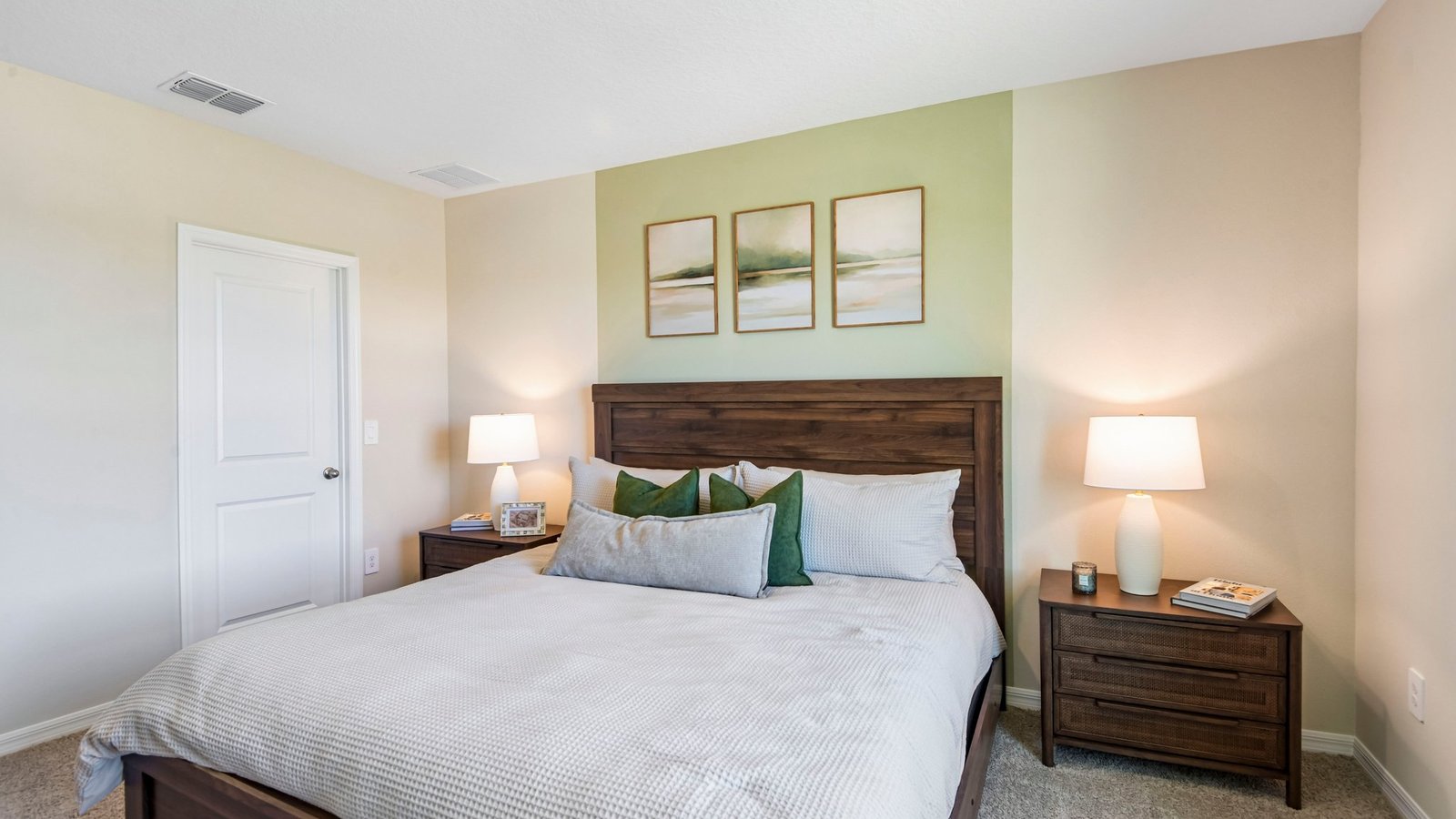 Spacious primary bedroom with king size bed, carpet flooring, natural lighting and a walk in closet.