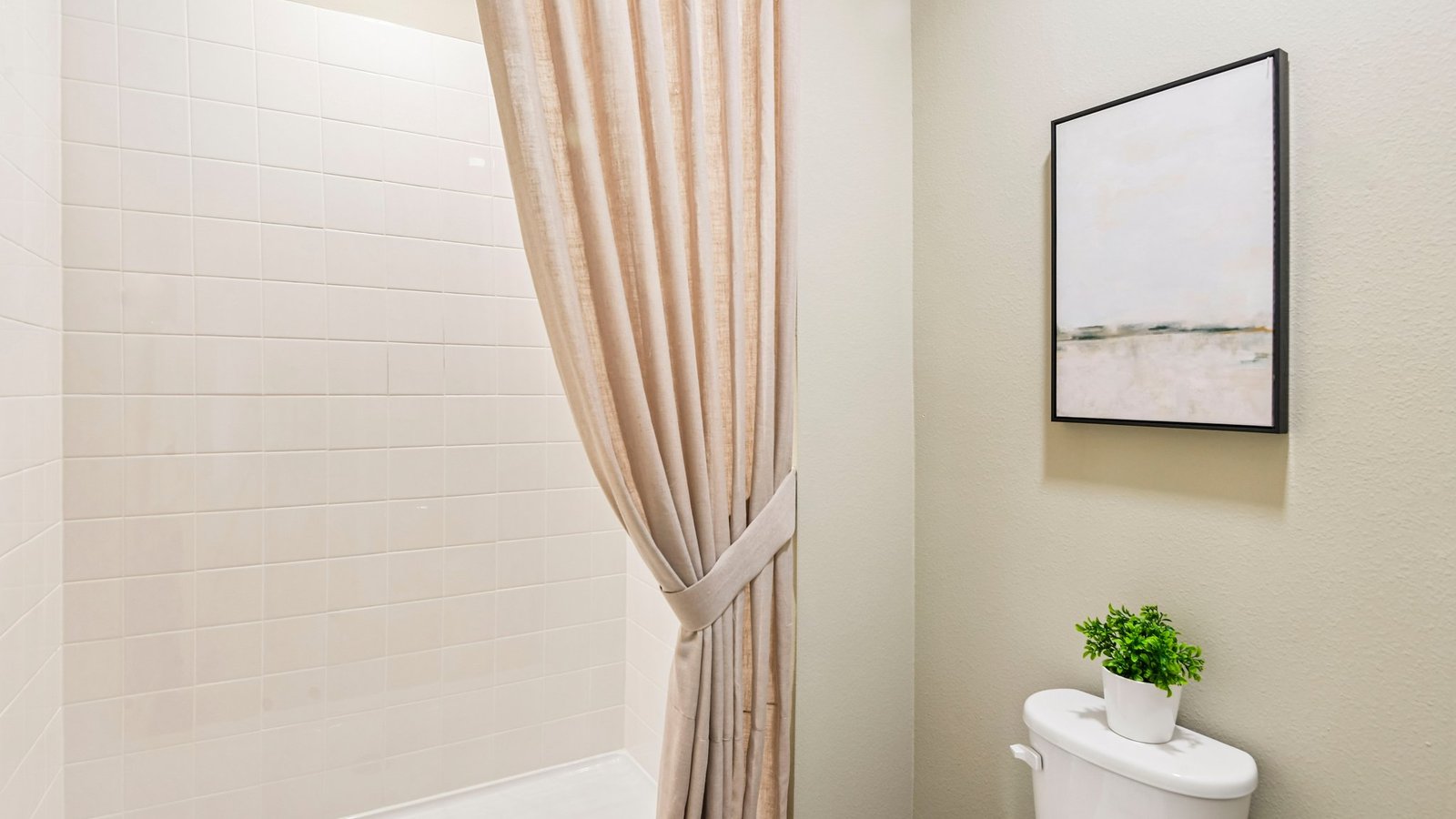 Modern bathroom with double vanity sinks, large wall mirror, cabinets and quartz countertops.
