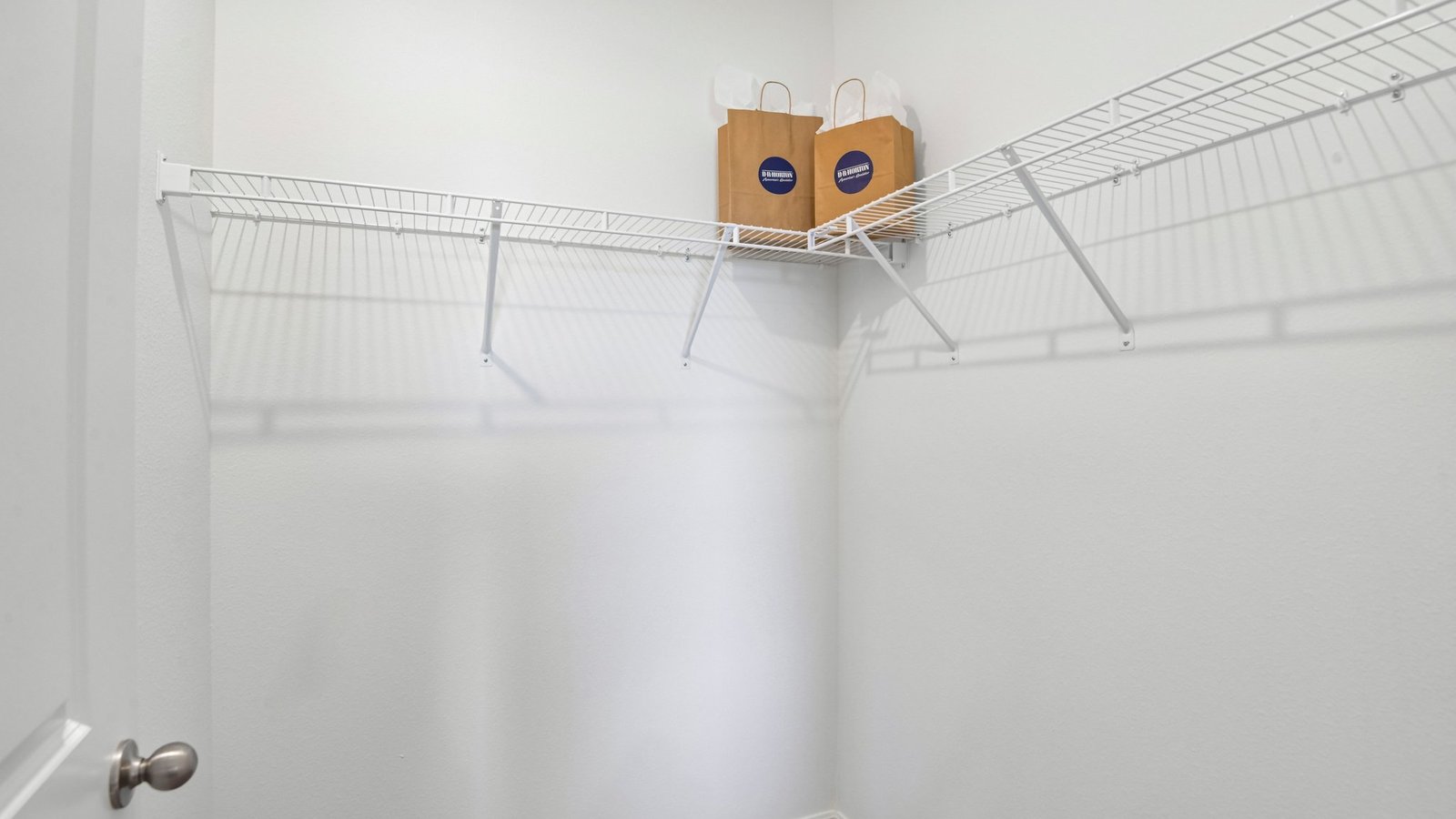 Spacious walk in closet with abundant shelving and storage.