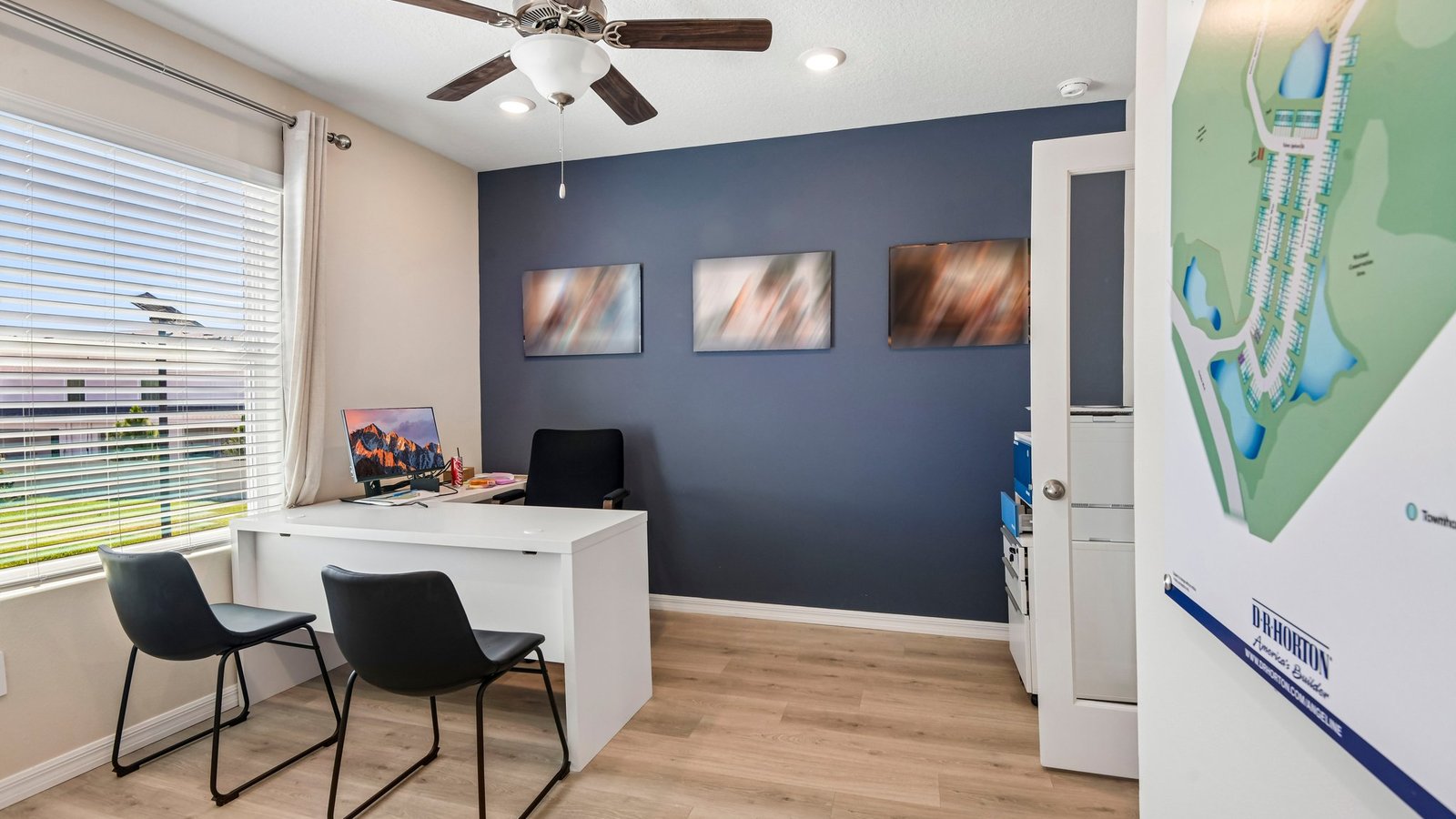 Multi-purpose office space with desk, seating and windows for natural lighting.