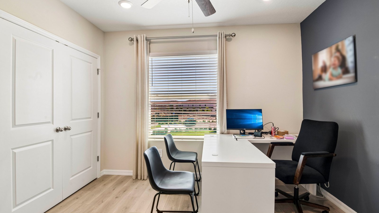 Multi-purpose office space with desk, seating and windows for natural lighting.