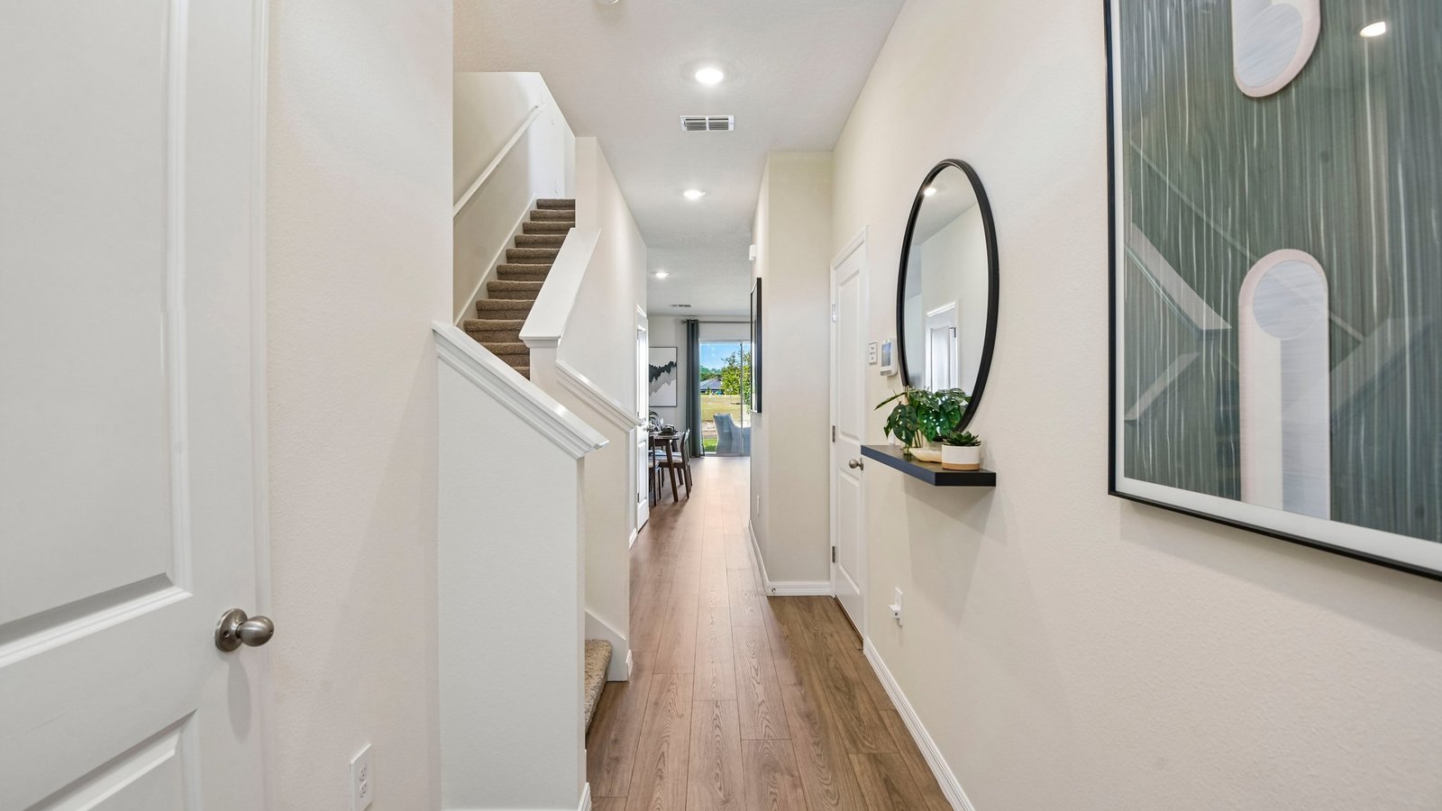 Home entry way thru the front door with LVP flooring and a view to the living space.