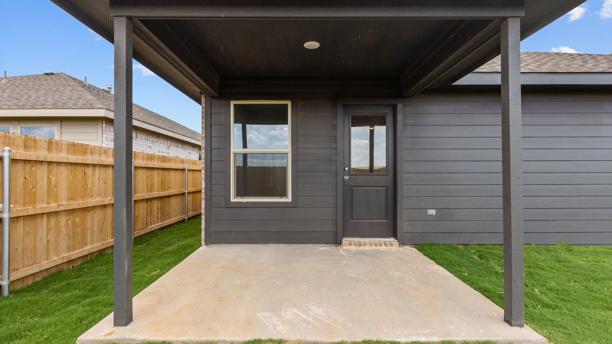 Covered back patio area overlooking spacious backyard