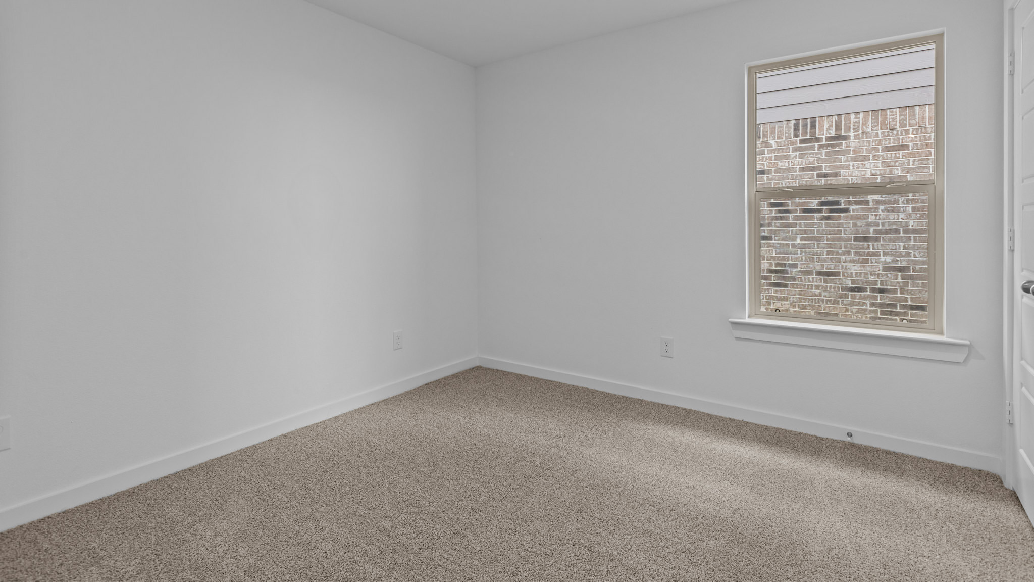 Guest bedroom 2 with side window and plush carpet floor
