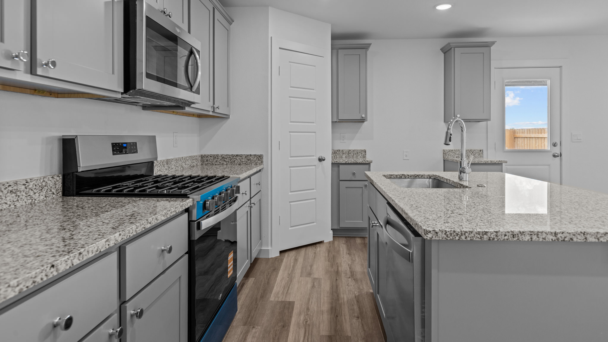 Open concept kitchen with stainless steel appliances, shaker style cabinets, and elevated finishes