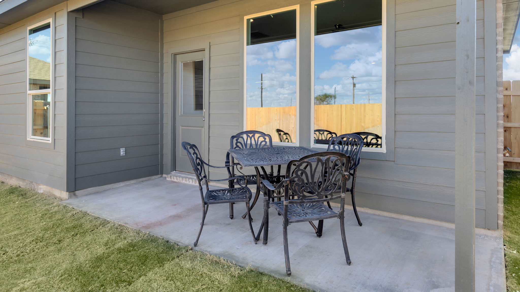Covered back patio area overlooking spacious backyard