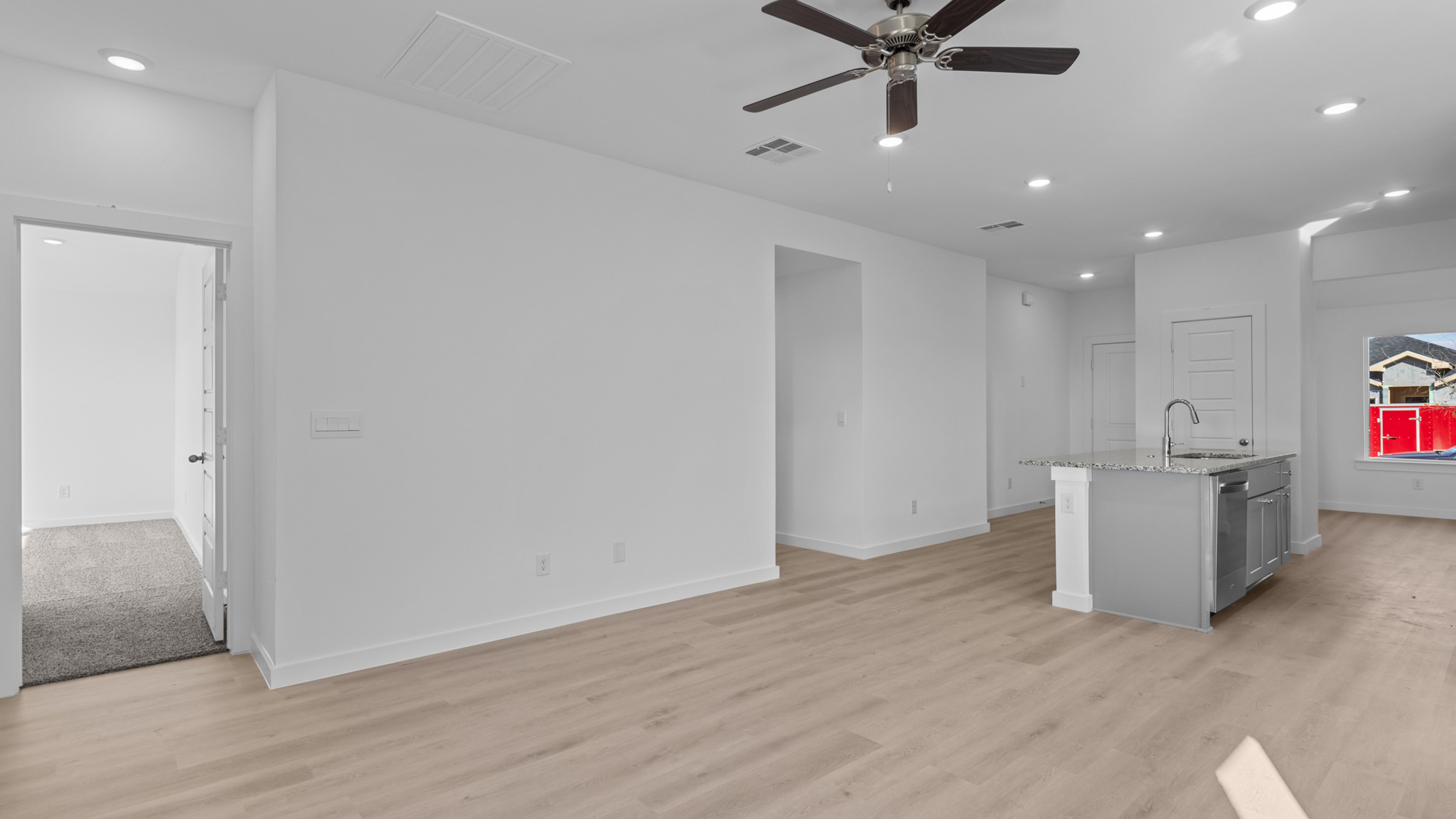 Open airy living space with vinyl flooring and white interior