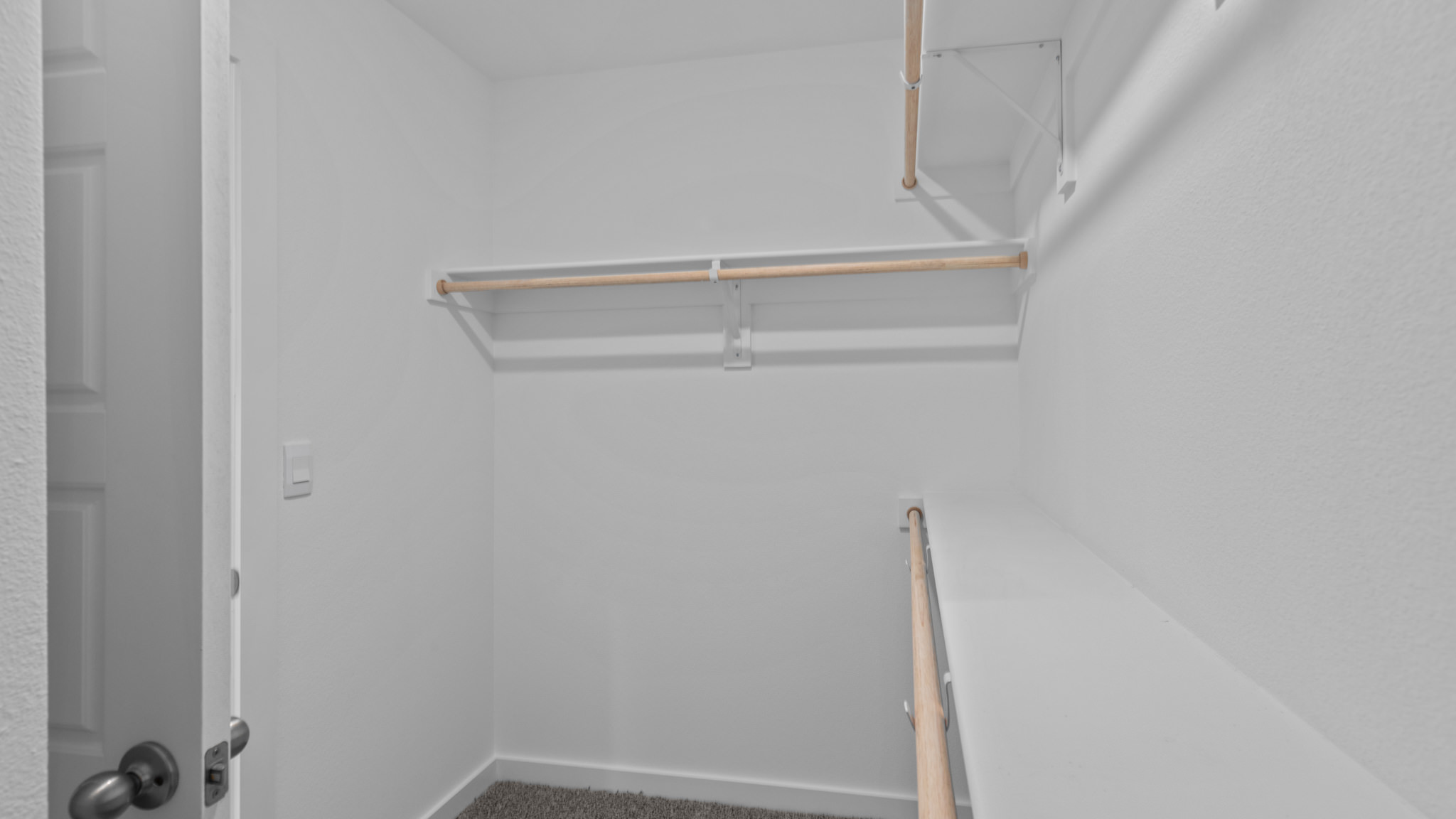 Primary walk-in closet with wooden shelving