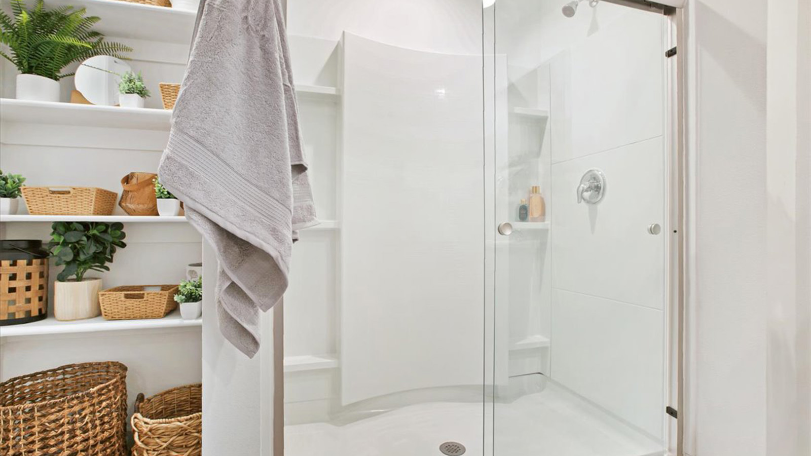 walk in shower with sliding glasss doors and wooden shelving on outside