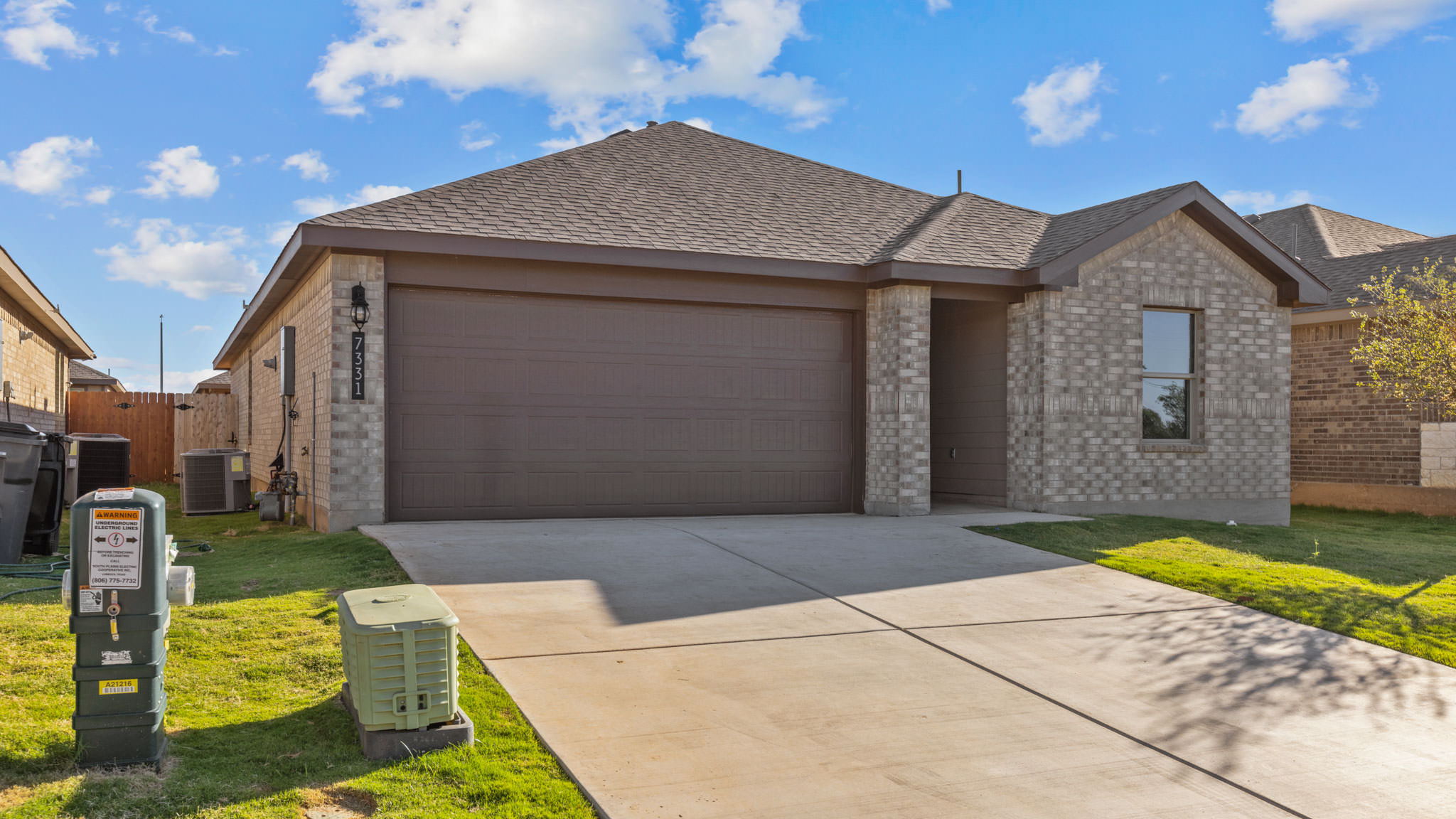 Single story home with brick, covered patio with 2 car garage